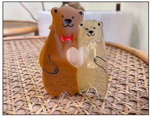 Détail de la pince à cheveux ours en acétate avec cœur ajouré et strass brillant