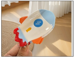 Dettaglio di una pinza per capelli a forma di razzo con finitura in resina colorata