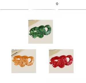 Detail of Chinese dragon hair claws in green, amber, and red with gold patterns