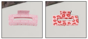 Détail de pinces à cheveux roses avec motif XOXO et imprimés lèvres rouges