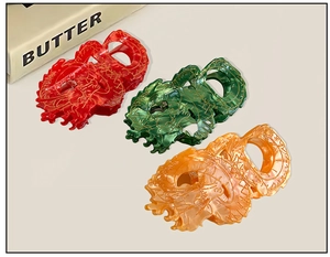 Detail of dragon-shaped hair claws in Chinese red, emerald green, and amber orange