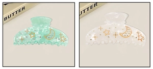 Detailed view of acrylic hair claws with marble texture and rhinestone star moon motifs