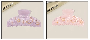 Detail of acrylic hair claws with marble texture and rhinestone star moon patterns