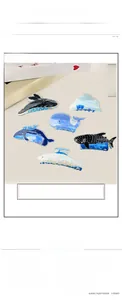 Détail des pinces à cheveux en acrylique motif baleine et dauphin de la série océan