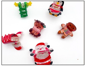 Dettaglio di fermagli per capelli natalizi con Babbo Natale, renne e alberi