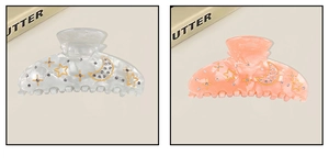 Detail of star and moon patterned acetate hair claws with sparkling rhinestones