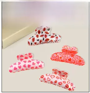 Set of four heart-shaped hair clips with red lip patterns in ivory and pink finishes