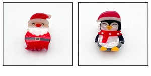 Dettaglio dei fermagli natalizi in acetato con motivi di Babbo Natale e del pinguino