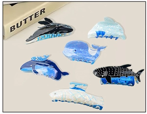 Détail de pinces à cheveux de 8 cm en acrylique avec motifs baleine et dauphin