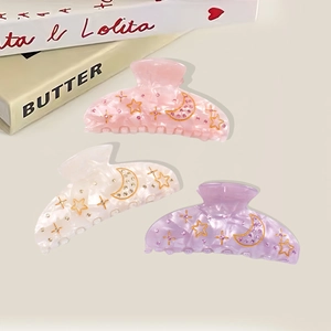 Three elegant acrylic hair claws with marble patterns, gold stars, and rhinestones