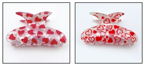 Détail de motifs de cœurs rouges sur pinces à cheveux en acrylique blanc perlé