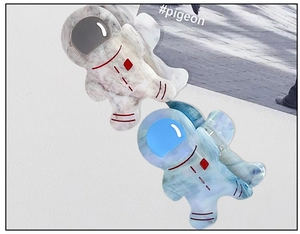 Detail of marble pattern acetate hair clips featuring cute astronaut and alien shapes