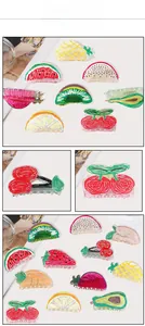Close-up of hand-painted acrylic fruit hair claws featuring strawberry and watermelon designs