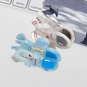 Cute astronaut acetate hair claws in marble blue and white set on a white desk