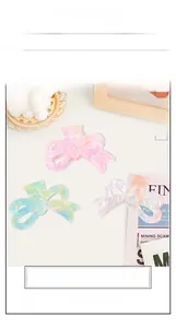 Detailed macro of large bow-shaped hair clips with colorful marble texture gradients