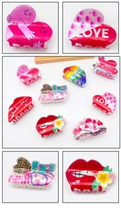 Detail of colorful acrylic hair claws featuring heart, lip, and rainbow LOVE patterns