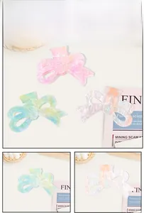 Detail of colorful bow-shaped acrylic hair claws with marble patterns for women