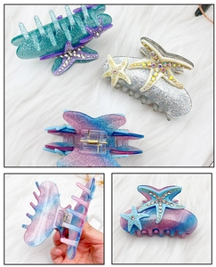 Détail de la pince à cheveux étoile de mer avec strass colorés et fini pailleté
