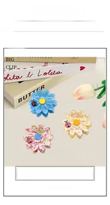 Detailed close-up of floral acetate hair claws with ladybug accent in three colors