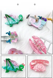 Détail de pinces à cheveux en acrylique aux motifs guitare, téléphone et scooter