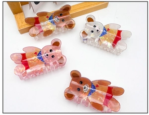 Gros plan de pinces à cheveux en forme d'ours avec paillettes et motifs imprimés colorés