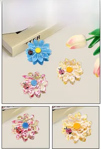 Detail of floral hair claws with marble texture and ladybug accent for women hair accessories