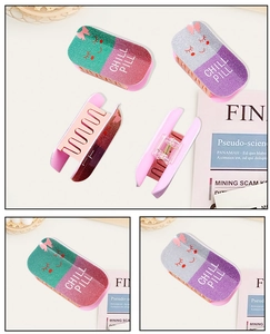 Detail of glitter acrylic chill pill hair claw clips with metal springs and face patterns