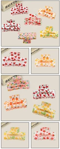 Detailed macro view of colorful PVC shark hair clips with diverse fruit pattern prints