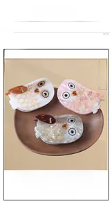 Detailed macro view of large owl-shaped cellulose acetate hair claws with marble textures