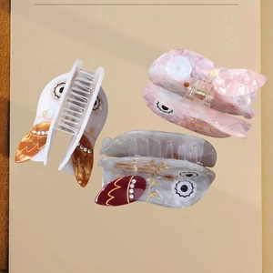 Elegant owl-shaped acetate hair claws with marble texture and rhinestone accents