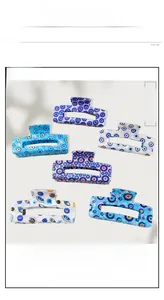 Detailed macro view of six rectangular Evil Eye hair claws in various blue and pink shades
