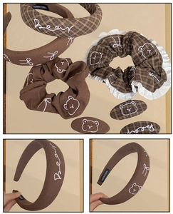 Close-up of brown checkered hair accessories set with lace and cute bear embroidery