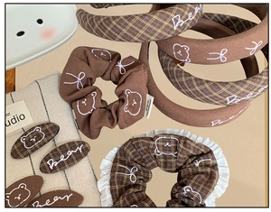 Detailed view of brown plaid scrunchie and bear embroidery hair accessories set