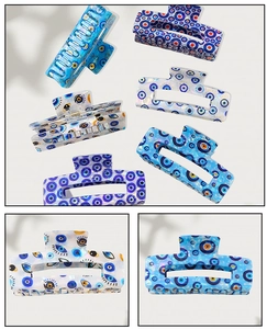 Detailed macro view of acetate evil eye hair claws with blue marble texture and unique patterns