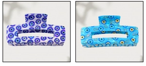 Detail view of blue evil eye hair claw clips with acetate texture and gold chain pattern