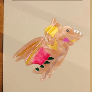 Cartoon dinosaur hair claw clip made of acetate with marbled pink finish and colorful details