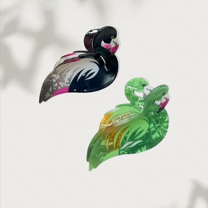 Pink and green flamingo-shaped hair claws with marble texture in a set of two