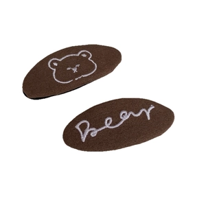 Brown fabric hair clips set with embroidered white bear head and cursive bear text