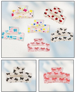 Detail view of acetate claw clips featuring floral, ladybug, and bow patterns with pearly texture