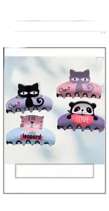 Detailed view of four colorful PVC cat and panda hair claws with cute cartoon illustrations