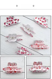 Detail view of pearlescent acrylic cowboy hat hair claw clips with heart and lip patterns