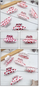 Detailed macro view of heart and red lip print acrylic cowboy hat hair claw clips