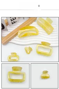 Detailed close-up of yellow amber acrylic hair claw clips in diverse geometric shapes