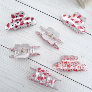 Pack of six cream acrylic claw clips with red lip and heart patterns for hair styling