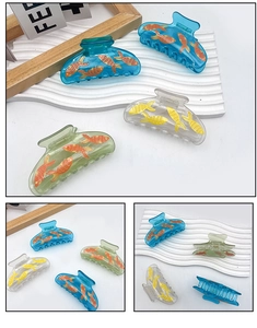Détail de pinces à cheveux en acrylique translucide avec motifs de poissons rouges vifs