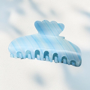 Light blue acetate hair claw clip with striped gradient and wavy scallop edge handle