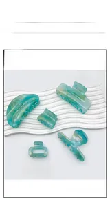 Detailed set of translucent blue-green acrylic hair claws with elegant golden flakes texture