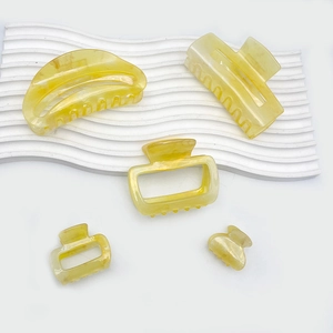 5-piece set of pale yellow marble acrylic hair claws in various geometric shapes and sizes