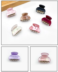 Macro detail of acrylic hair claw clips with marble texture and metal electroplated teeth