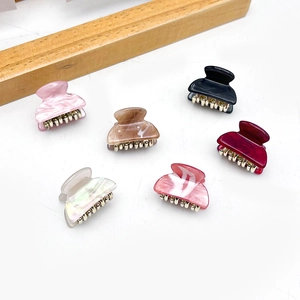 Set of six colorful acrylic mini hair claws with marble texture and gold teeth details